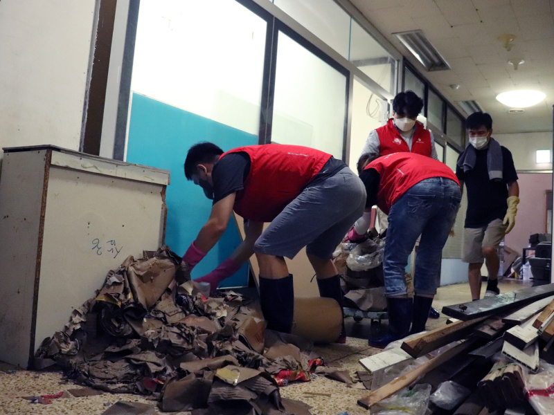 임직원 3명이 지하에서 쓰레기를 옮기며 치우고 있다.