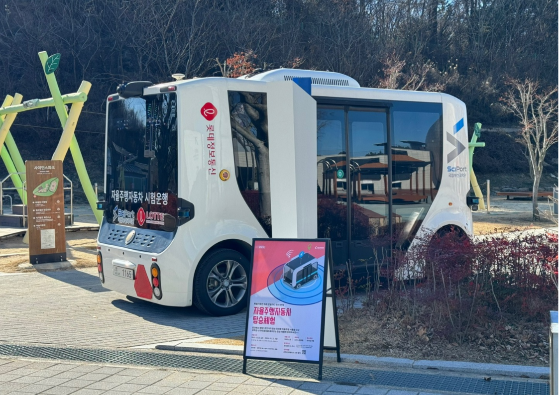 A self-driving shuttle stands in front of the pavilion.